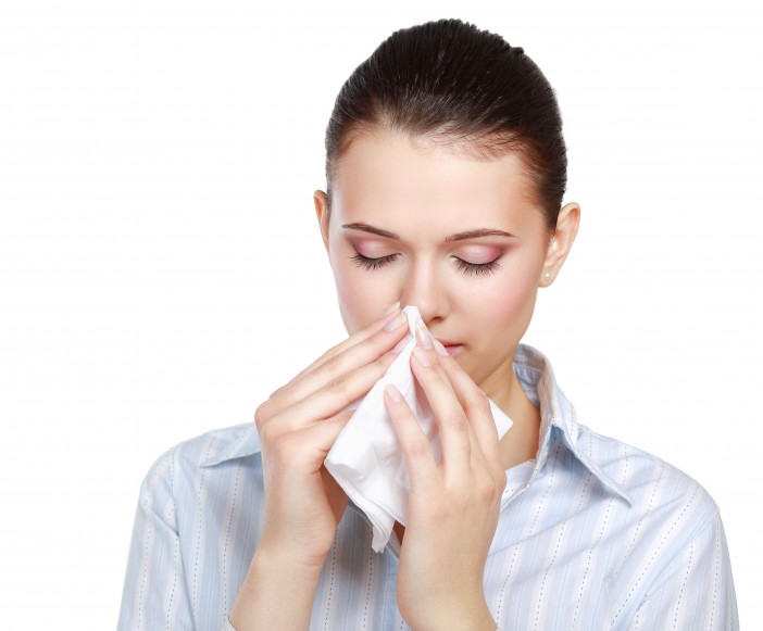 Sick woman blowing her nose, white background